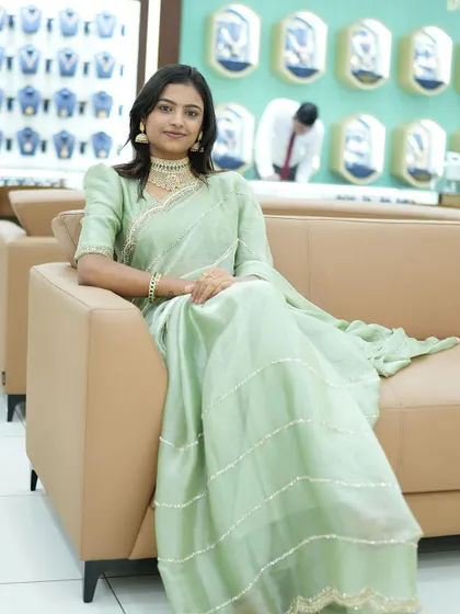 Sonu seated comfortably, looking chic and relaxed in our designer saree.