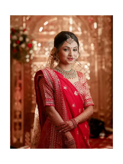 A lovely portrait of the bride, her traditional red lehenga and jewelry looking magnificent.