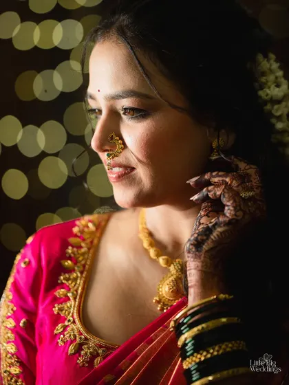 A beautiful profile shot of a bride, highlighting her traditional nose ring and the intricate details of her makeup.