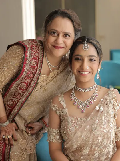 A glowing mother and daughter duo. The mother's makeup features a soft, luminous base and defined eyes, a timeless look that enhances her features without feeling heavy.