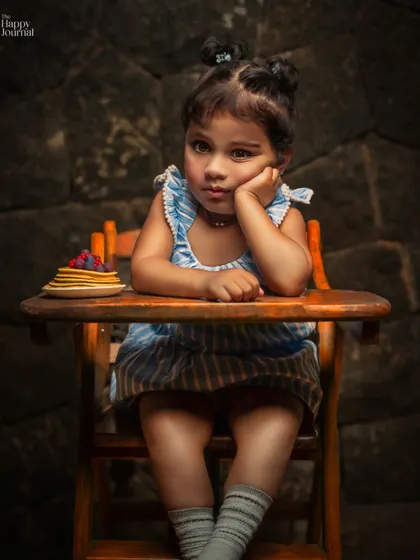 A little philosopher with her pancakes. This creative portrait captures a thoughtful, funny moment, telling a story with a single look.