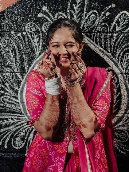 The same happy bride, her joy evident in this playful pose against a cool mural.