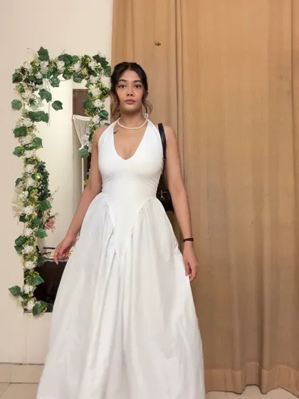 A full-length view of the white halter dress, showing off its beautiful flow and structure. It’s a truly timeless piece.