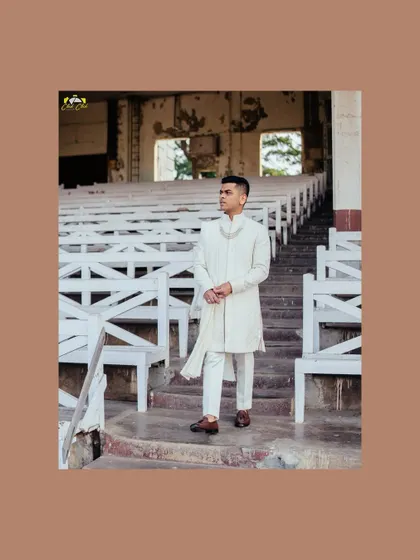 A classic groom portrait in a unique setting. The old-world charm of the amphitheater-style seating provides a striking contrast to the groom's crisp, modern sherwani.