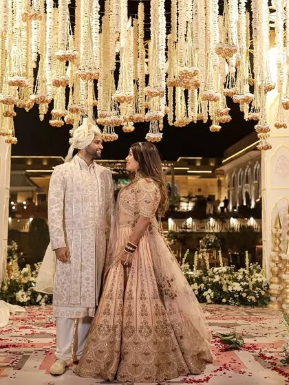 A beautiful portrait of the couple under the floral-laden mandap, showcasing the grandeur and romance of the setting at night.