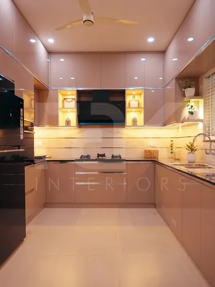 A sleek and modern kitchen with glossy beige cabinets and integrated appliances. The under-cabinet lighting and open display shelves provide both functionality and a stylish touch.