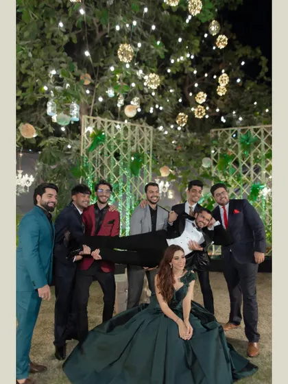 The groomsmen having fun with the groom. This candid shot shows the camaraderie and playful energy of the groom and his friends during the reception.
