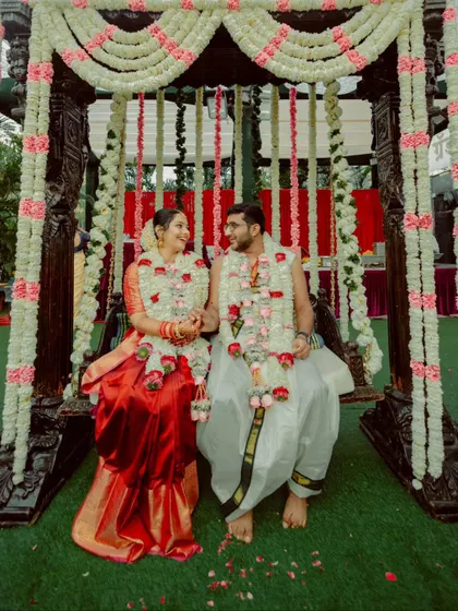 The couple seated on the traditional Oonjal (swing), a beautiful and significant part of a South Indian wedding.