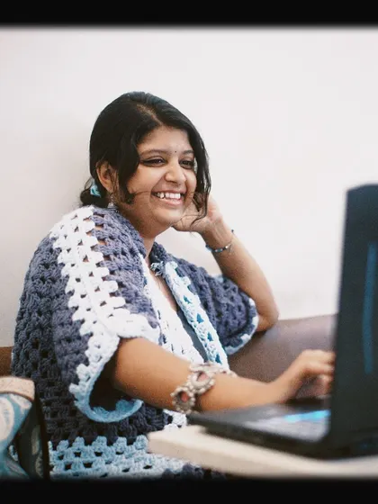 A smiling customer working on her laptop, perfectly capturing the joy of finding a great spot to be productive.