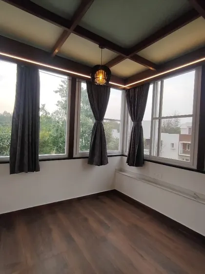 An interior view of a sunroom we constructed. Featuring a wood-beamed glass ceiling and large windows on all sides, this space is designed to be a bright and peaceful retreat with panoramic views of the outdoors.