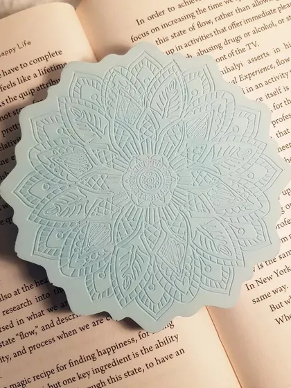 A direct overhead shot of the icy blue Mandala coaster, showing the crispness of the pattern.