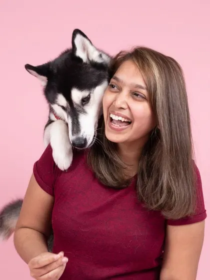 A joyful moment in the studio as Ella the Siberian Husky gives her human a happy hug from behind.
