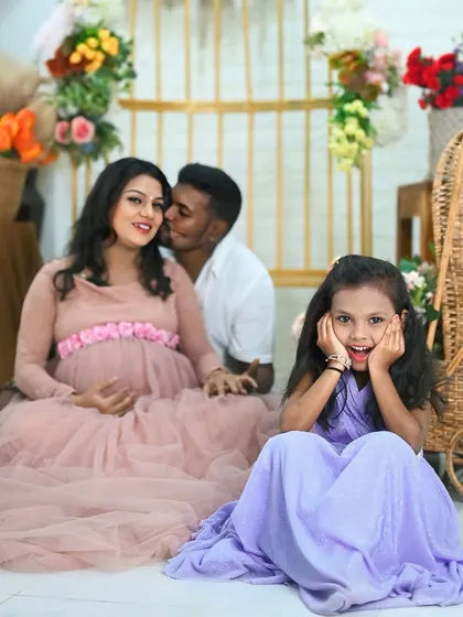 The whole family is excited. This photo captures the parents' love and the big sister's happy curiosity all in one frame.