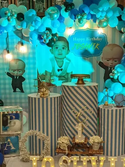 A cool Boss Baby theme for a first birthday. The blue and white color scheme, striped pedestals, and character cutouts create a sharp and fun look.