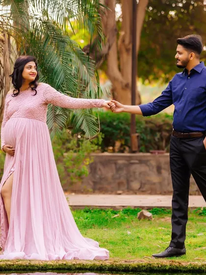 A classic "leading the way" pose by the water's edge. This outdoor maternity photo captures the couple's journey together, set against a beautiful natural landscape.
