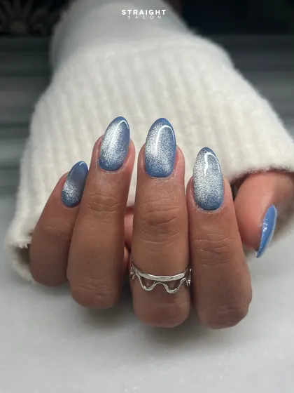 A beautiful blue and silver cat-eye effect on natural oval nails. This magnetic polish creates a galaxy-like shimmer that is both dreamy and sophisticated.