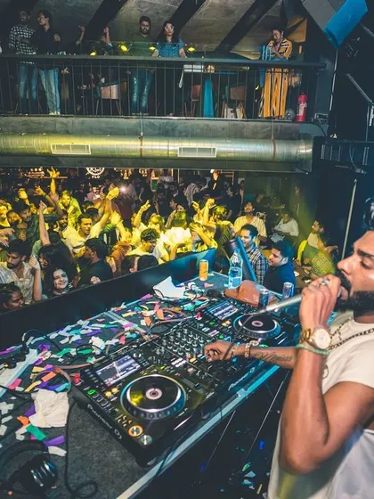 A high-angle shot showing me on the mic, overlooking a packed dance floor. I make sure to engage with every corner of the room.