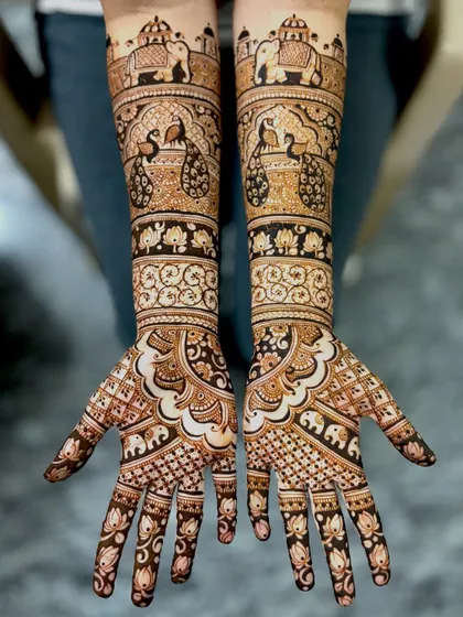 For the bride who loves classic elegance, this design is a perfect choice. It features majestic peacocks and royal elephants, symbols of grace and strength, woven into a traditional full-coverage pattern that extends up the forearms.