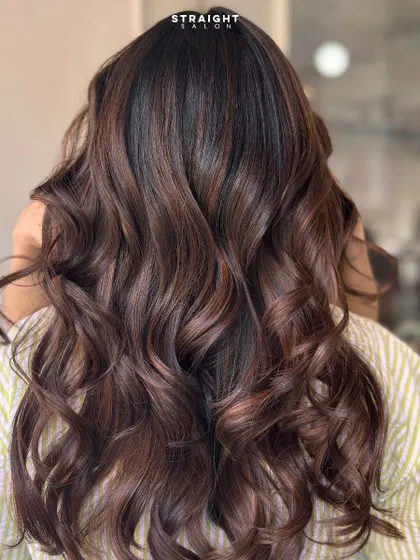 Balayage that blends like a dream. This look features a seamless transition from a dark root to lighter, warmer ends.