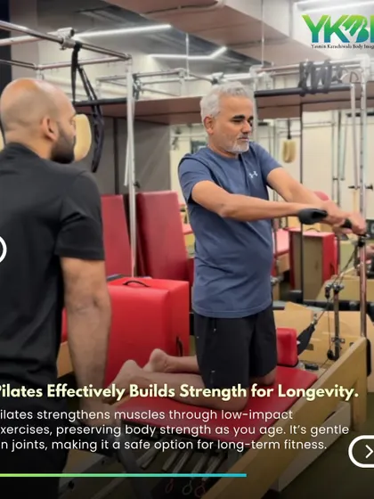 Pilates effectively builds strength for longevity. Here, a trainer guides an older client through a reformer exercise, demonstrating the low-impact approach that preserves joint health.