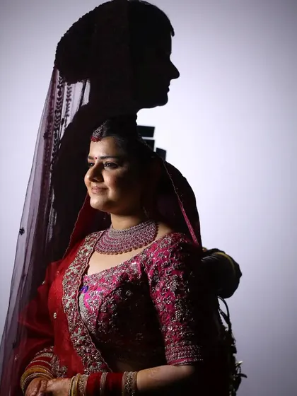 A creative double-exposure style portrait, blending a lit portrait of the bride with her own silhouette.
