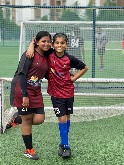 Besties at Playsmart, where friendships and skills grow together. Two of our female players share a happy moment on the pitch.