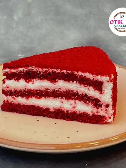 A classic Red Velvet Pastry slice. The striking red sponge is layered with our signature cream cheese frosting, creating the perfect balance of tangy and sweet in every bite.