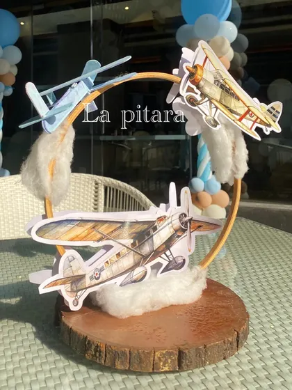 A creative table centerpiece featuring vintage airplane models flying through cotton clouds, perfect for an adventure-themed party.