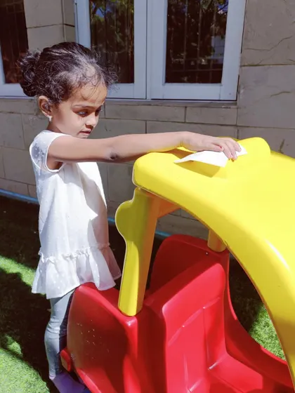 Helping to clean the toy car. These simple chores teach children important life skills and the value of contributing to a group.