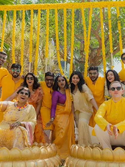 The whole family joins in the fun! This photo captures the joyful spirit of the Haldi ceremony, set against our vibrant backdrop of hanging marigold strings.