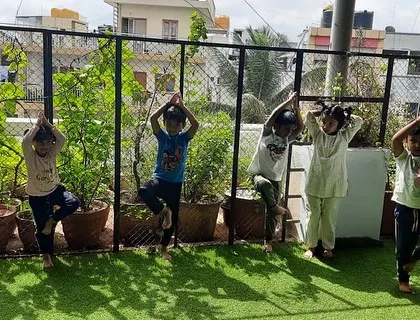 On World Yoga Day, children practice the tree pose in our outdoor area. Yoga helps them develop balance, concentration, and a connection between their mind and body.