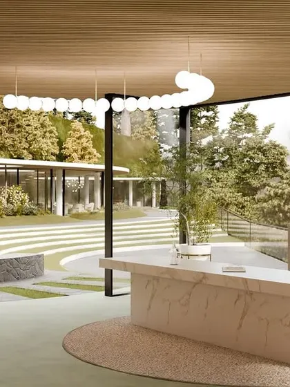 The reception area of the resort, with a marble desk and an open-air design that looks out onto the terraced landscape and fire pit.