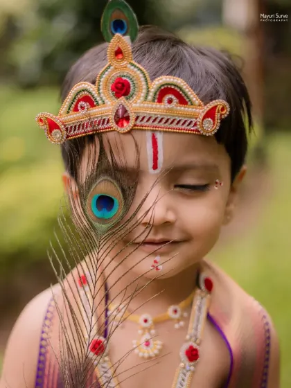 Children's photoshoots are pure joy. For this Janmashtami theme, we captured this little one's innocent expression as Krishna, using a peacock feather to create a unique and artistic composition that families will treasure.