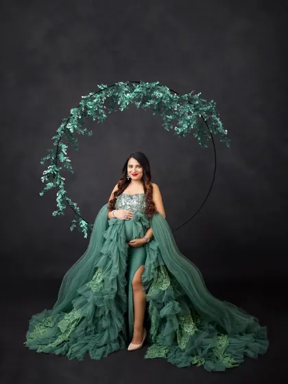 A truly luxurious look. This sequined and ruffled green gown is a masterpiece, and the sparkling greenery hoop adds the perfect finishing touch.