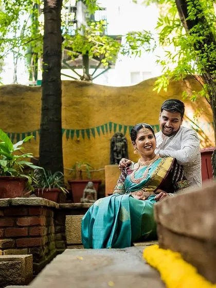 A wide shot of the couple in a serene, traditional courtyard, showing the beautiful ambiance of the location.