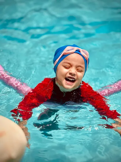 That look of pure delight! This young swimmer is enjoying her time in the water, a key goal in our beginner swimming lessons.