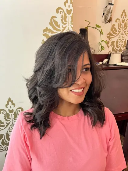 Invisible layers and side-swept bangs to work with Anupama’s natural hair texture.