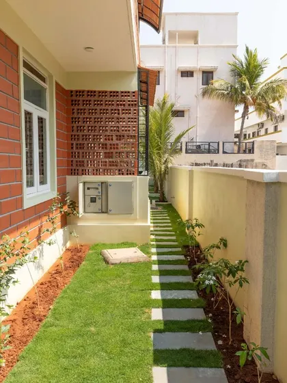 A narrow garden path beside the house, showing how greenery can be used to soften the building's edges.