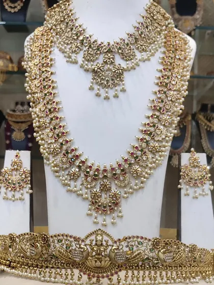 A gorgeous guttapusalu-inspired set, featuring clusters of pearls. This set includes a choker, a long haram, and a Lakshmi-motif vaddanam.