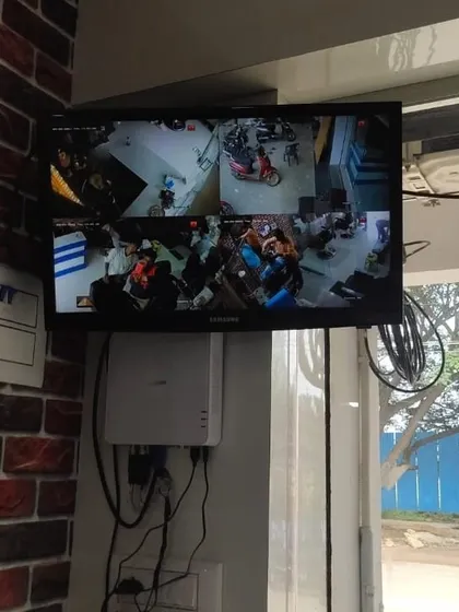 The monitor for the salon installation, mounted high on a brick-patterned wall.