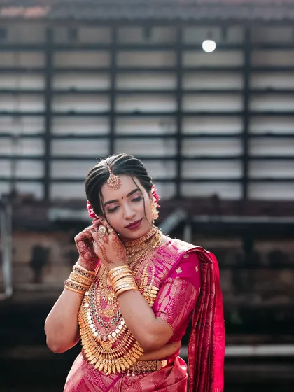 A stunning close-up of the bride adjusting her elaborate gold jewellery.