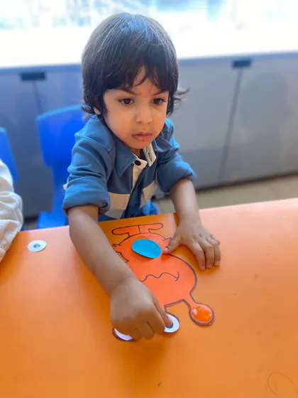 A close-up of a boy carefully assembling his alien craft. These projects require focus and help children learn to follow multi-step instructions.