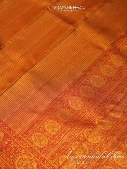 A close-up of the intricate weaving on the pallu, with rows of circular buttas.