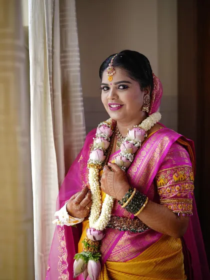 A close-up of the bride's pink and yellow saree look, showing the elephant motifs embroidered on the puff sleeves of her blouse.