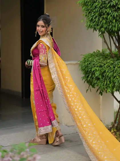 The long trail of the saree adds a touch of drama and elegance. This shot captures the complete look, from the intricate hairstyle to the traditional draping.