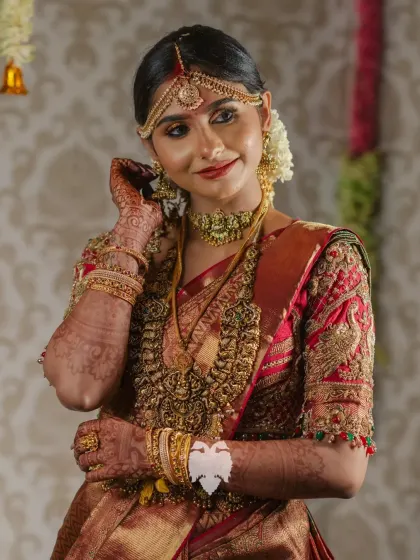 Priya, radiant on her wedding day, her maroon raw silk blouse dazzling with zardosi, kundans, and beads.