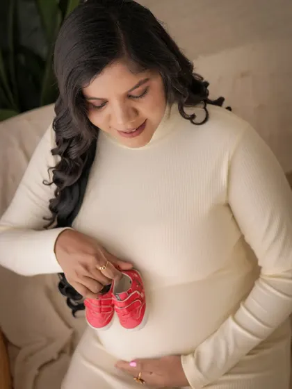 A sweet close-up shot featuring a pair of baby shoes. This is a classic and heartwarming way to add a personal and anticipatory touch to your maternity photos.