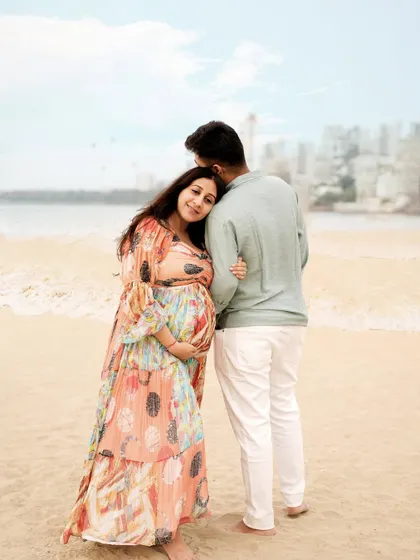 A tender moment on the beach, with the city skyline in the background, blending urban and natural elements.