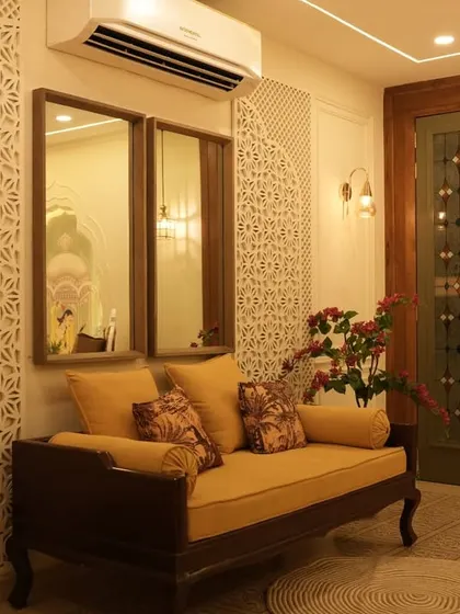 This seating nook features a traditional wooden divan against a wall with intricate jali paneling. The design is a nod to classic Indian architecture, creating a cozy and culturally rich corner.
