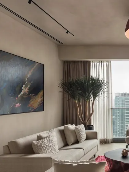 A large abstract painting serves as a stunning focal point in the East Coast Residence living room. The colors in the artwork are echoed in the rug, tying the whole space together.